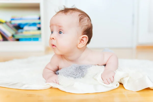 Schattige baby tot op de vloer op haar buik — Stockfoto