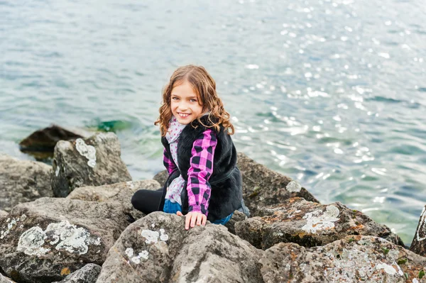 Außenporträt eines niedlichen kleinen Mädchens, das an einem frischen Tag am See spielt — Stockfoto