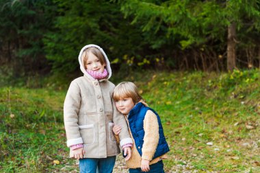 Bir ormandaki bir soğuk hava üzerinde oynayan iki sevimli çocuklar