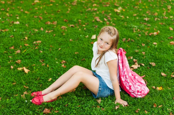 Malá holčička, spočívající v parku po škole — Stock fotografie
