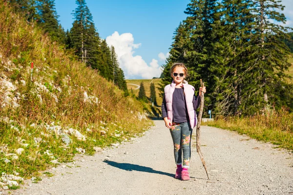 Niedliches kleines Mädchen, das an einem schönen sonnigen Tag in den Bergen wandert — Stockfoto
