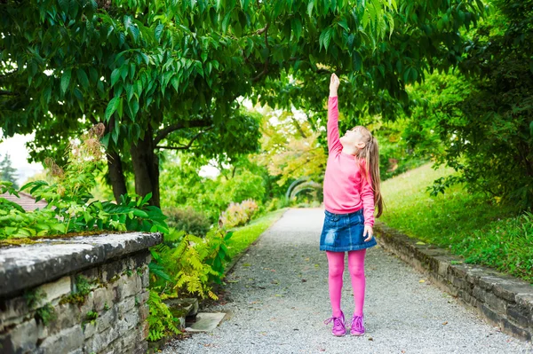 Außenporträt eines entzückenden kleinen Mädchens, das in einem Park spielt — Stockfoto