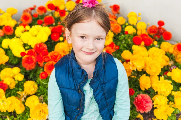 Outdoor portrait of adorable little girl against colorful flowers — Stock Photo, Image