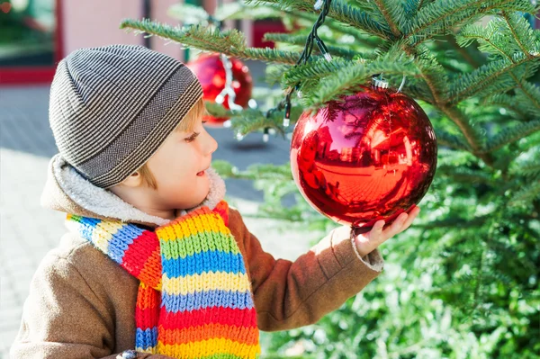 Bonito menino brincando com árvore de natal ao ar livre — Fotografia de Stock