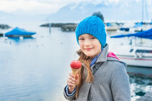 Очаровательная маленькая девочка ест мороженое на открытом воздухе — стоковое фото
