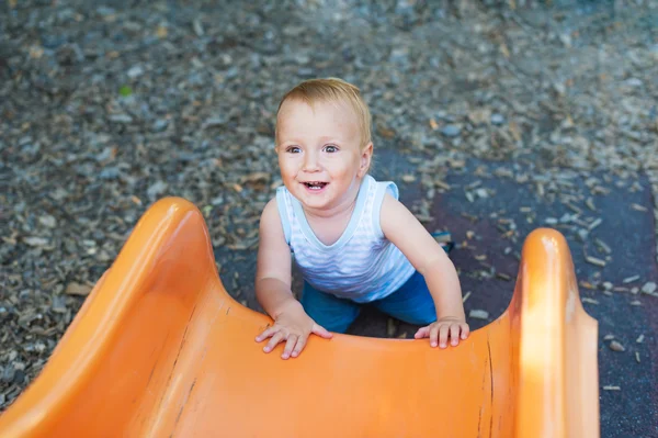 Adorável criança menino se divertindo ao ar livre, escalando no playground — Fotografia de Stock