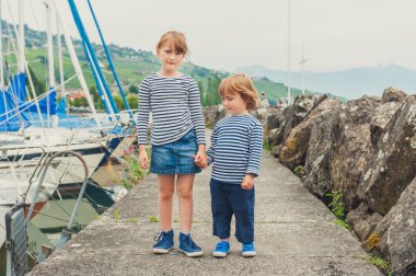 Çocuklar, küçük kız ve frocks, giyen erkek elele, limanda oynayan iki moda