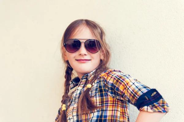 Porträt eines niedlichen kleinen Mädchens mit gelb-blau kariertem Hemd und Sonnenbrille, getöntes Image — Stockfoto