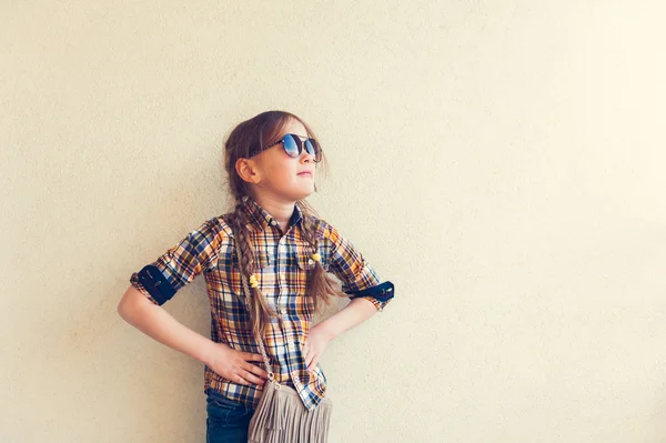 Retrato de una linda niña usando camisa a cuadros amarilla y azul y gafas de sol — Foto de Stock