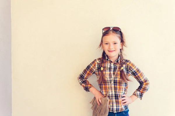 Retrato de uma menina bonita vestindo camisa xadrez amarelo e azul e óculos de sol — Fotografia de Stock