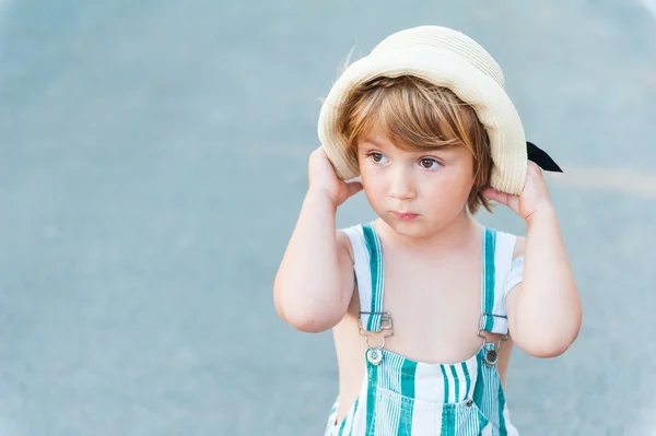 Summer portrait of adorable toddler boy, wearing overalls and hat — Stock Photo, Image