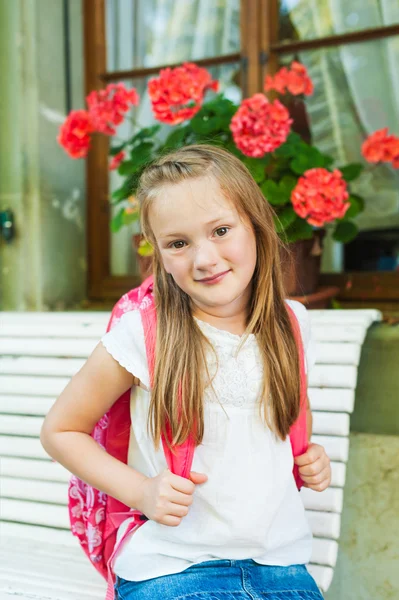 Sevimli küçük bir kız okuldan sonra bir bankta oturan açık portresi — Stok fotoğraf