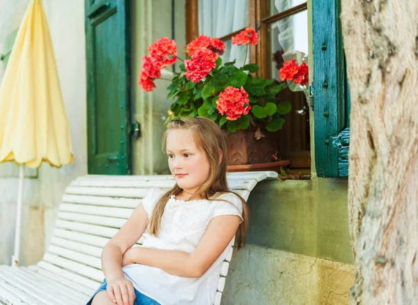 Außenporträt eines niedlichen kleinen Mädchens, das auf einer Bank ruht — Stockfoto