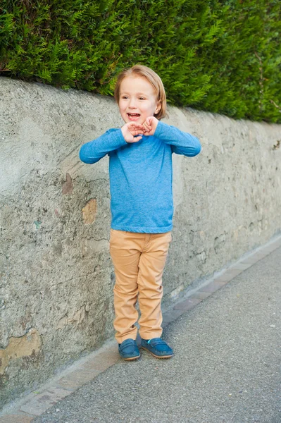 Внешний портрет очаровательного мальчика в голубой футболке, бежевых брюках и темно-синих мокасинах — стоковое фото