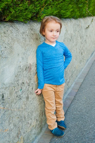 Retrato ao ar livre de menino adorável vestindo camiseta azul, calças bege e mocassins azuis escuros — Fotografia de Stock