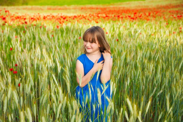 Cute little girl playing in a wheat field on a summer day — Stock Photo, Image