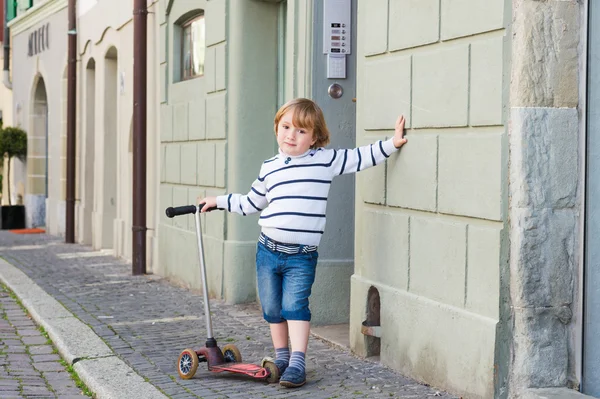 Utomhus porträtt av en söt liten pojke på 4 år, klädd i vit tröja och jeans shorts — Stockfoto