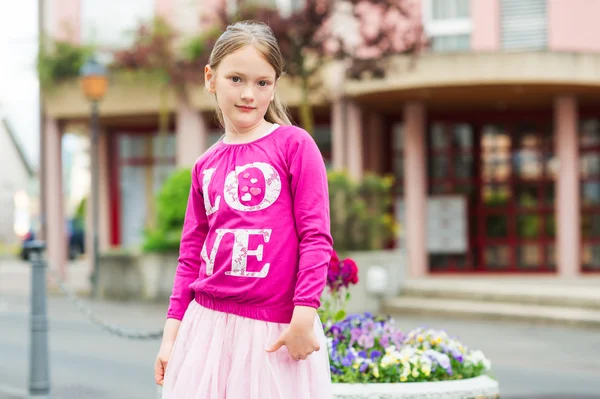 一个漂亮的小女孩，穿着明亮的粉红色顶部和兔兔裙子的室外肖像 — 图库照片