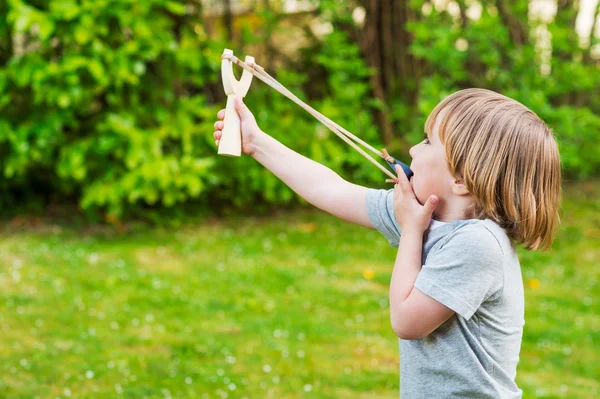 Niedliche kleine Junge spielt mit Schleuder, im Freien — Stockfoto