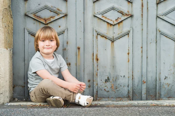 Retrato ao ar livre de um menino loiro bonito de 4 anos, vestindo camiseta cinza, calças bege e sandálias brancas — Fotografia de Stock
