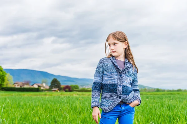 Модный портрет милой маленькой девочки 7 лет, в голубых брюках и вязаной куртке — стоковое фото