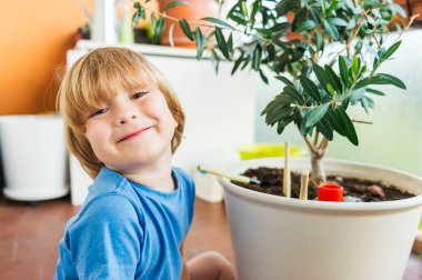 Bahçe aletleri ile balkonda oynayan sevimli küçük çocuk