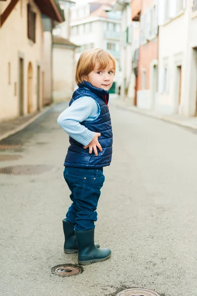 Outdoor Portret van een schattige kleine jongen, het dragen van blauwe vest en regen laarzen — Stockfoto