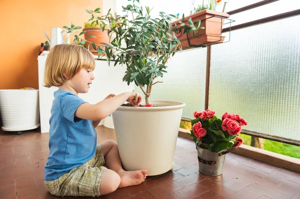 Schattige kleine jongen spelen met tuingereedschap op het balkon — Stockfoto