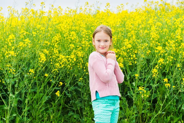 Portrait en plein air d'une jolie petite fille jouant avec des fleurs dans une campagne — Photo