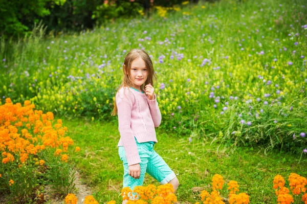 Carina bambina che gioca in un parco, indossando pullover rosa — Foto Stock