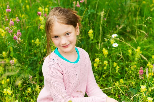 Menina bonito jogando em um parque, vestindo pulôver rosa — Fotografia de Stock