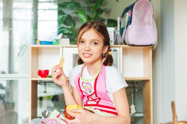 Sevimli küçük kız evde oynarken, kurabiye yemek