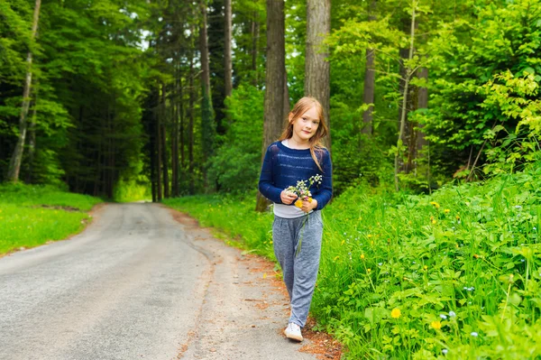 Carina bambina di 7 anni che gioca in una foresta, raccogliendo fiori selvatici — Foto Stock