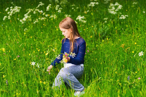 Söt liten flicka på 7 år gammal spelar i en skog, plocka vilda blommor — Stockfoto