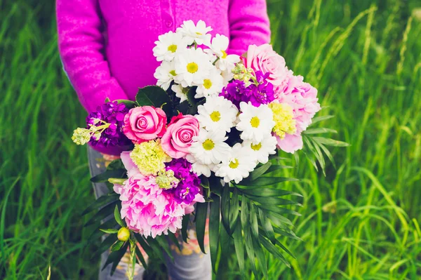 Piękny bukiet kwiatów jasny i kolorowy posiadania przez dziecko w ręce — Zdjęcie stockowe