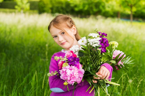 Retrato ao ar livre de uma menina bonita com belo buquê de flores — Fotografia de Stock