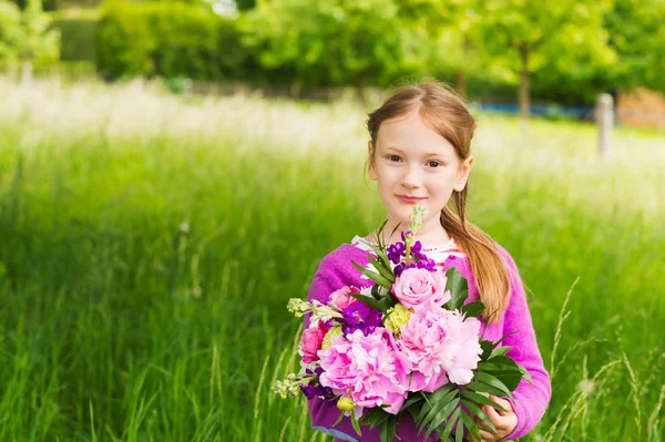 一个可爱的小女孩与束美丽的鲜花的室外肖像 — 图库照片