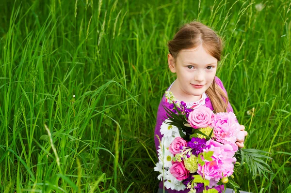 Retrato ao ar livre de uma menina bonita com belo buquê de flores — Fotografia de Stock