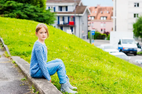 Модный портрет 7-летней девочки в синем трикотажном свитере, джинсах с поясом — стоковое фото