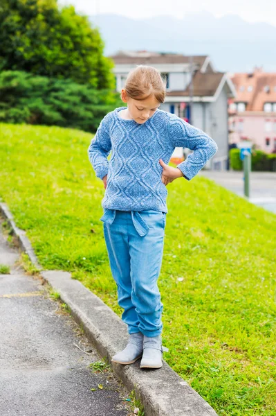 Fashion portrait of a pretty little girl of 7 years old, wearing blue knitted pullover, jeans with belt — Stock Photo, Image