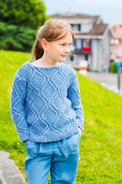 Retrato de moda de uma menina bonita de 7 anos, vestindo pulôver de malha azul, jeans com cinto — Fotografia de Stock