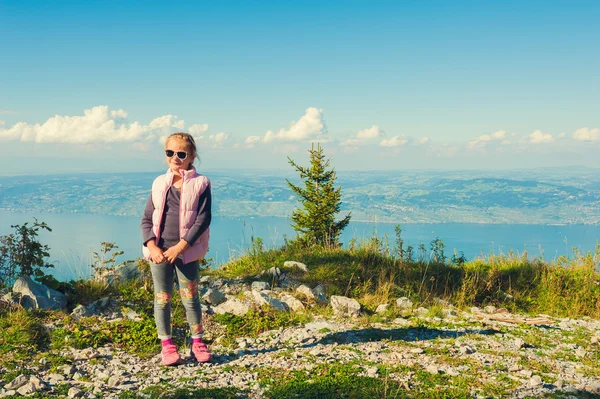 Niedliches kleines Mädchen auf dem Gipfel des Berges in den französischen Alpen mit Blick auf die Schweiz, getöntes Bild — Stockfoto