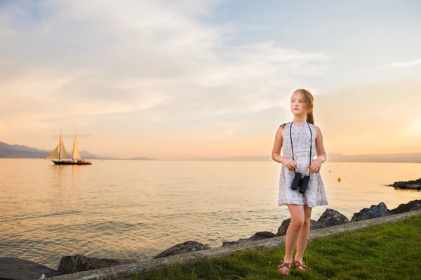 Außenporträt eines netten kleinen Mädchens, das an einem schönen warmen Abend am See spielt — Stockfoto