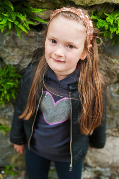 Retrato ao ar livre de uma menina bonito de 5 anos de idade, vestindo casaco de couro preto — Fotografia de Stock