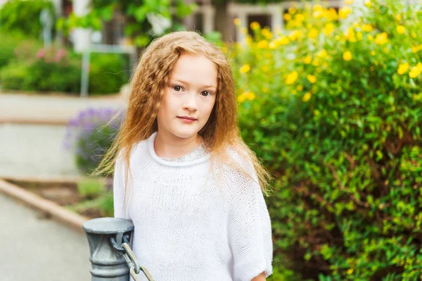 Außenporträt eines süßen kleinen Mädchens in einer Stadt, das einen weißen Pullover trägt — Stockfoto