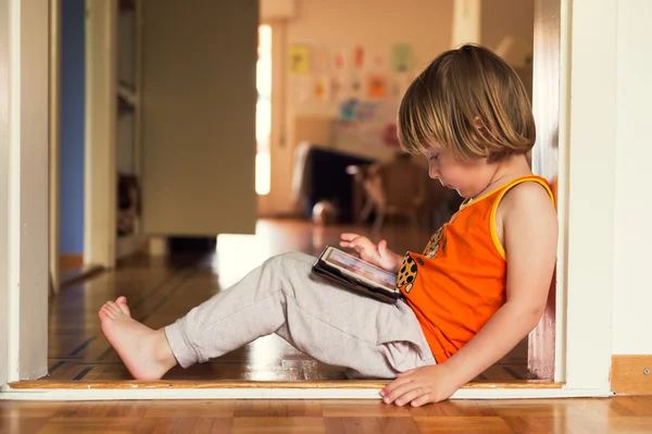 Menino adorável brincando em um tablet digital — Fotografia de Stock