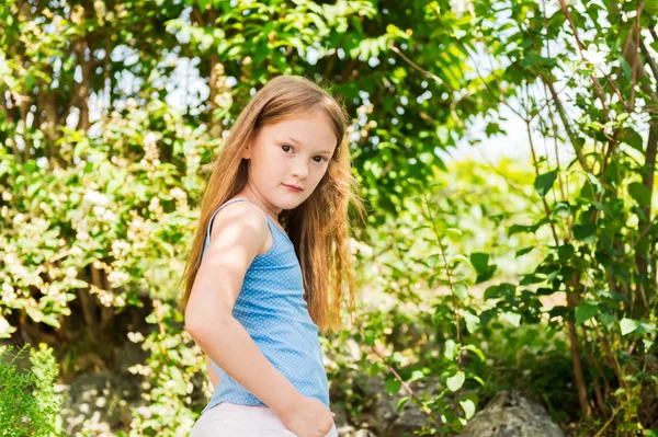 Retrato ao ar livre de uma linda menina brincando em um jardim em um dia ensolarado agradável — Fotografia de Stock