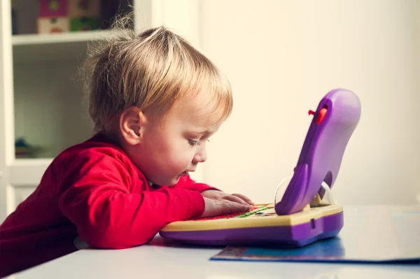 Lindo bebé jugando con la computadora, imagen tonificada —  Fotos de Stock