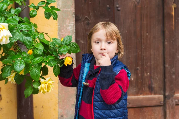 Ritratto all'aperto di un piccolo ragazzo biondo carino, che indossa pullover caldo e gilet — Foto Stock