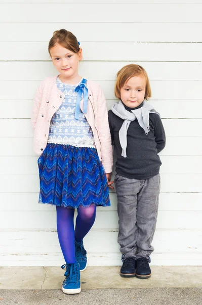 Dvě děti módní bílé dřevěné stěny — Stock fotografie